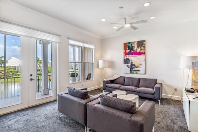 living room with ornamental molding, ceiling fan, and dark colored carpet