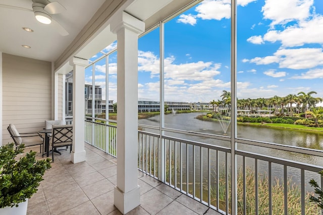 sunroom with a water view and ceiling fan