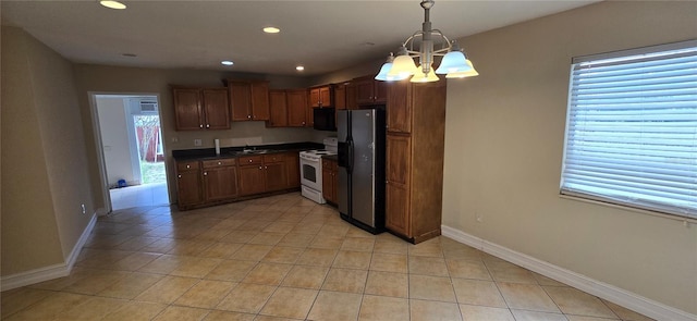 kitchen with decorative light fixtures, sink, a chandelier, white electric range oven, and stainless steel fridge with ice dispenser