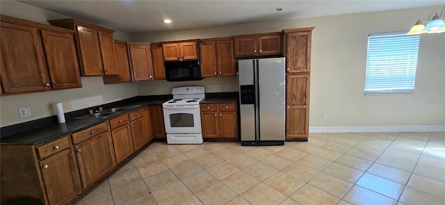 kitchen featuring sink, white electric range, stainless steel fridge, and light tile patterned floors