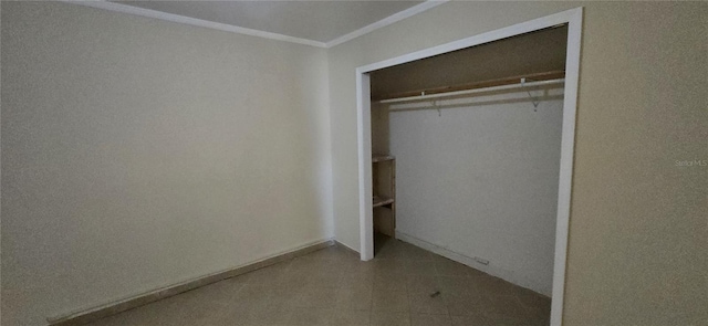 unfurnished bedroom with ornamental molding and a closet