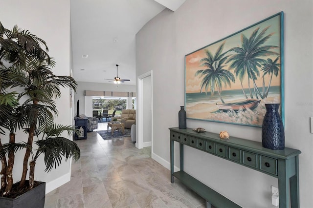 hallway featuring a high ceiling and baseboards