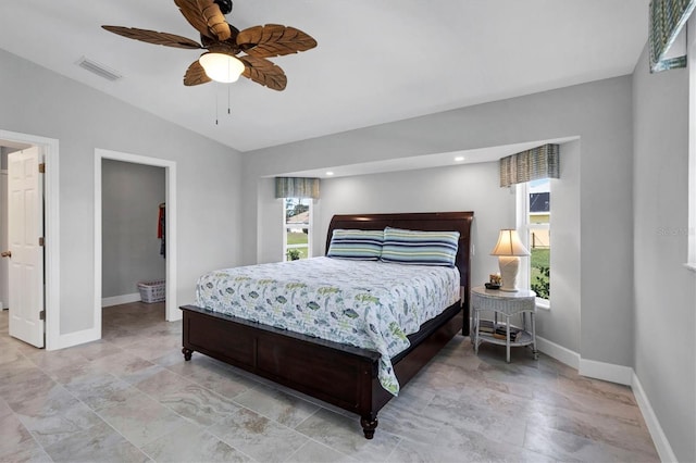 bedroom featuring lofted ceiling, visible vents, a spacious closet, a ceiling fan, and baseboards