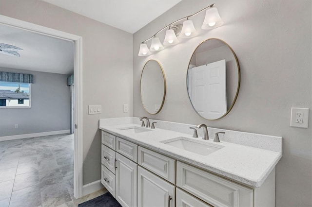 full bath with a sink, baseboards, and double vanity