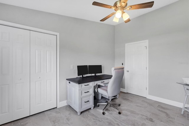 office space with baseboards and a ceiling fan