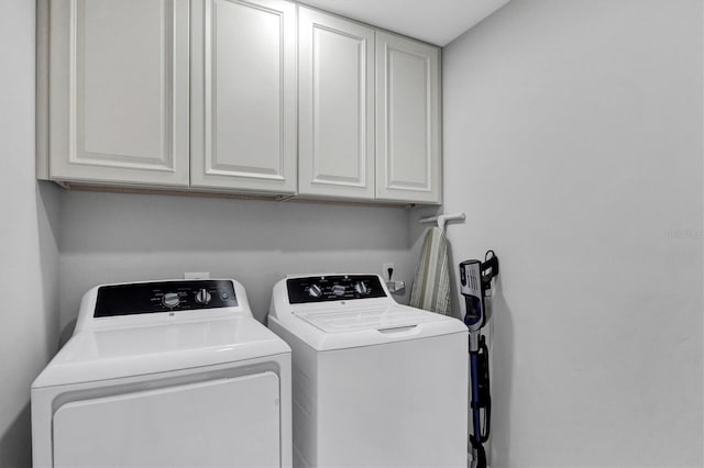 laundry room featuring independent washer and dryer and cabinet space