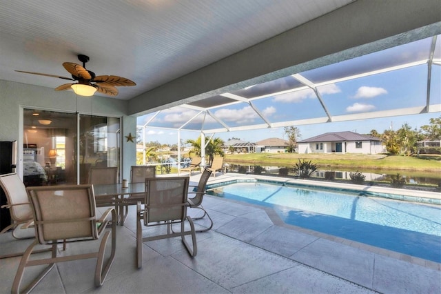 outdoor pool featuring a patio, a water view, a ceiling fan, glass enclosure, and a residential view