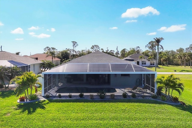 rear view of property featuring a lanai, a lawn, and a patio