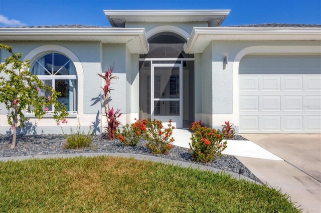 property entrance featuring a garage and stucco siding