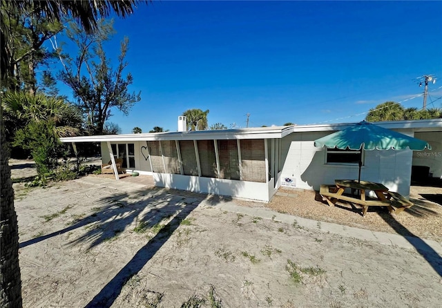 rear view of property featuring a patio and a sunroom