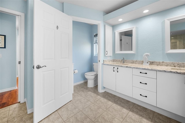 bathroom featuring vanity, tile patterned floors, and toilet