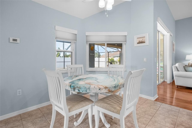 tiled dining room featuring vaulted ceiling and ceiling fan