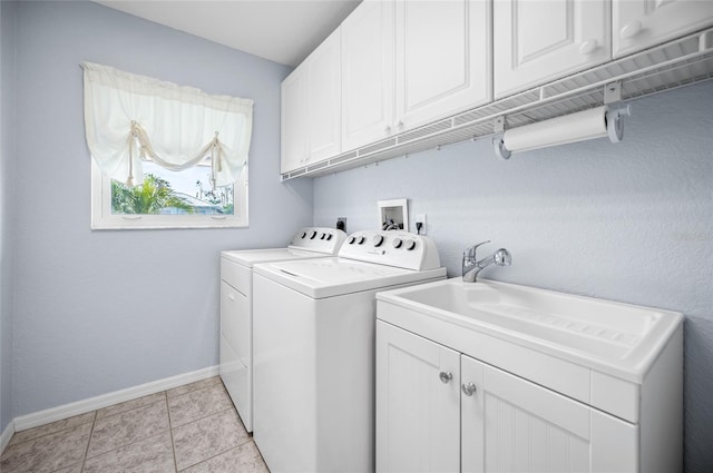 washroom featuring washer and clothes dryer, cabinets, and light tile patterned flooring