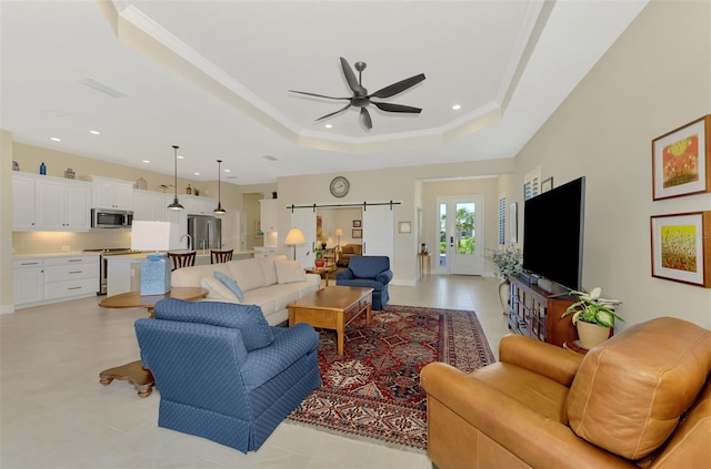 living room featuring crown molding, a raised ceiling, and ceiling fan