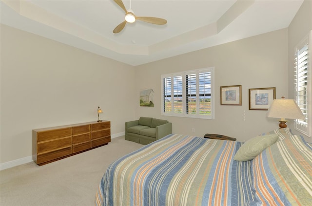 bedroom with carpet floors, a raised ceiling, and ceiling fan