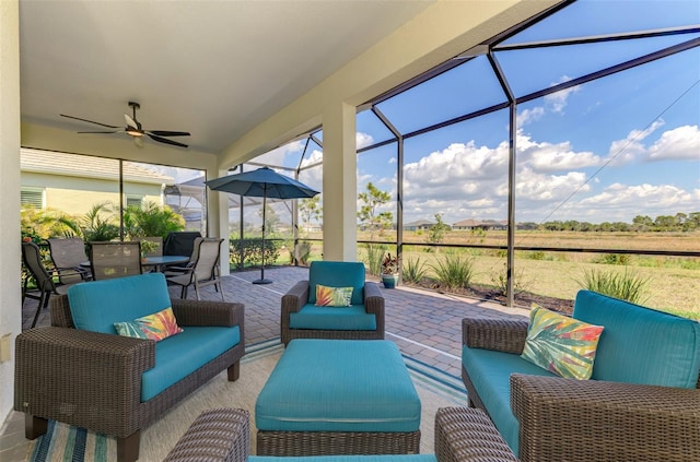 sunroom / solarium featuring ceiling fan and a rural view