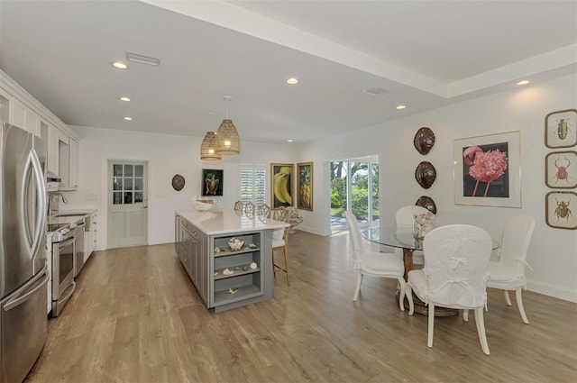 kitchen featuring gray cabinets, a kitchen island, appliances with stainless steel finishes, white cabinets, and hanging light fixtures