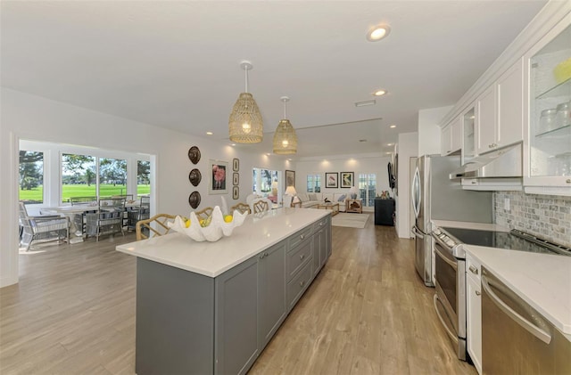 kitchen featuring gray cabinetry, tasteful backsplash, decorative light fixtures, appliances with stainless steel finishes, and white cabinets