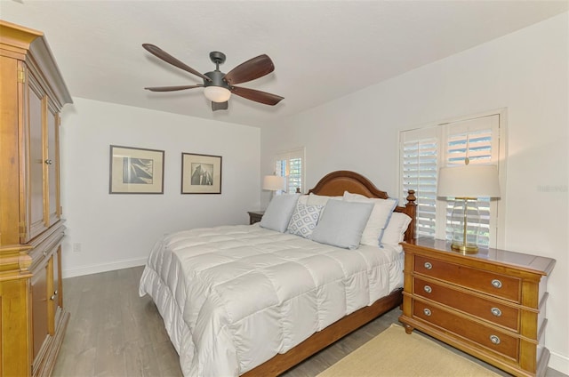 bedroom with multiple windows, hardwood / wood-style floors, and ceiling fan