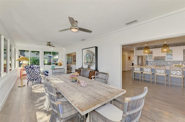 dining space with ceiling fan and light hardwood / wood-style flooring