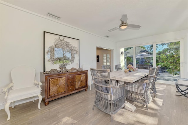 dining area with ceiling fan and light hardwood / wood-style flooring