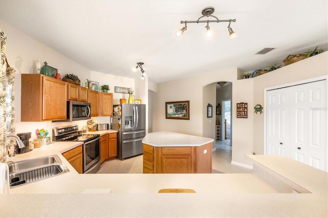 kitchen featuring appliances with stainless steel finishes, kitchen peninsula, sink, and light tile patterned floors