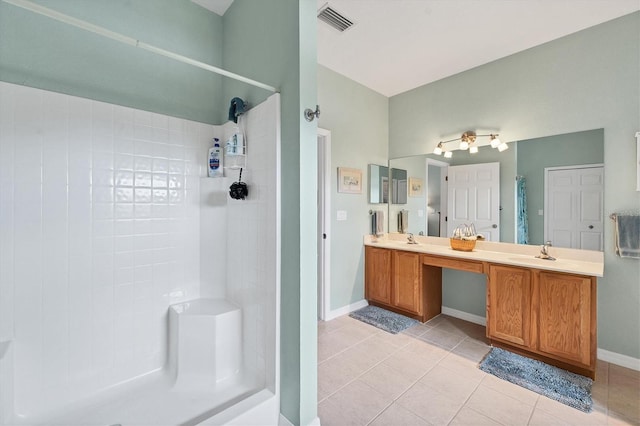 bathroom featuring vanity, tile patterned floors, and tiled shower