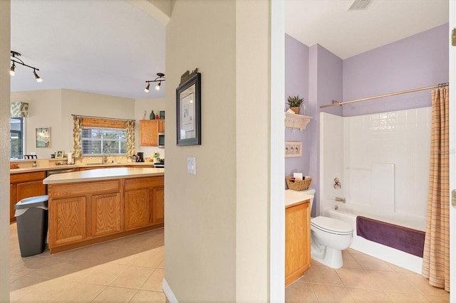 full bathroom featuring tile patterned flooring, vanity, toilet, and shower / bath combo with shower curtain