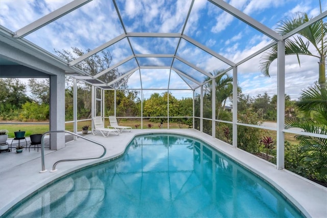 view of pool with a patio and glass enclosure