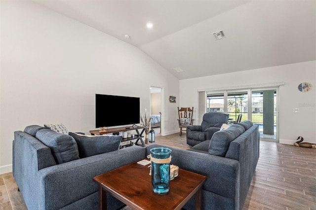 living room with high vaulted ceiling and light hardwood / wood-style flooring