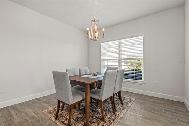 dining space with hardwood / wood-style flooring and an inviting chandelier