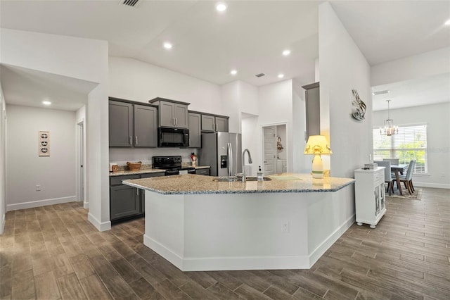 kitchen with dark wood-type flooring, sink, light stone counters, gray cabinets, and black appliances