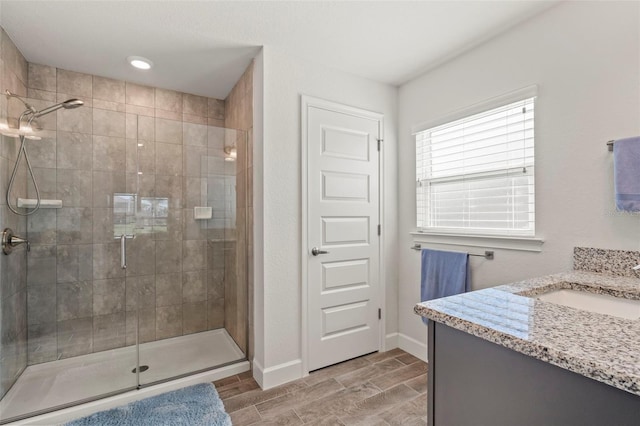 bathroom featuring vanity and a shower with door