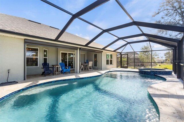 view of pool with an in ground hot tub, glass enclosure, and a patio