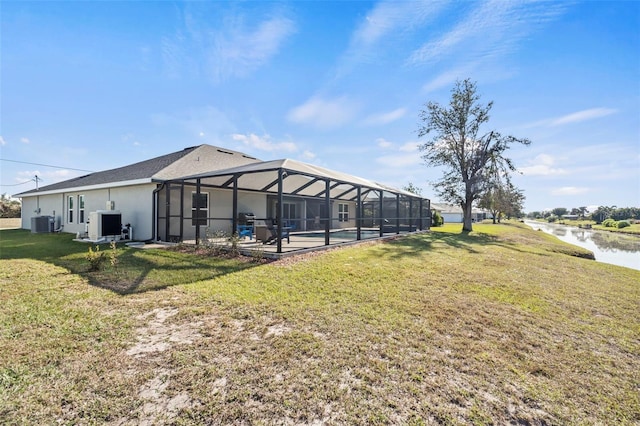 exterior space featuring a water view, a lanai, a lawn, and cooling unit