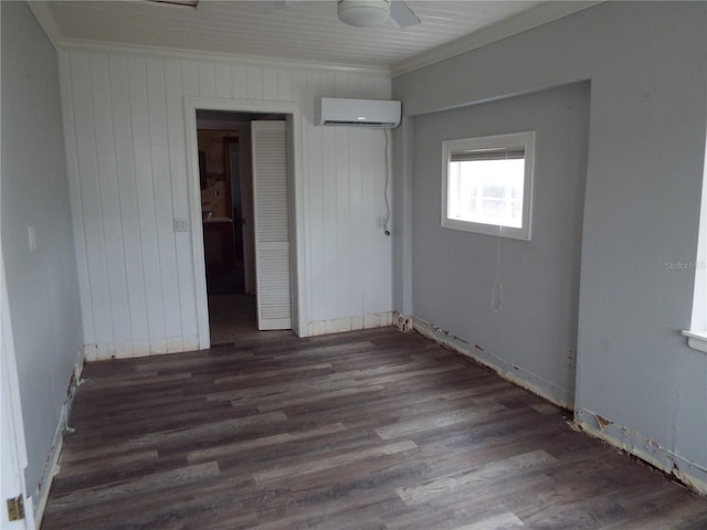 unfurnished bedroom featuring ornamental molding, dark hardwood / wood-style flooring, and a wall mounted AC