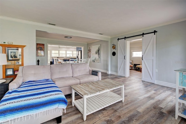 living room featuring crown molding, a barn door, and hardwood / wood-style floors