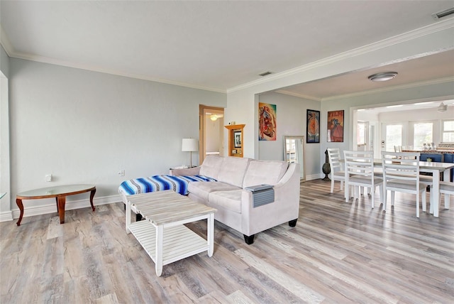 living room with crown molding and light hardwood / wood-style flooring