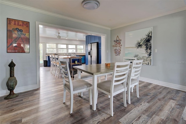 dining area with wood-type flooring and crown molding