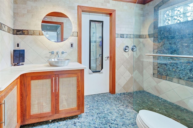 bathroom with vanity, a tile shower, backsplash, and toilet