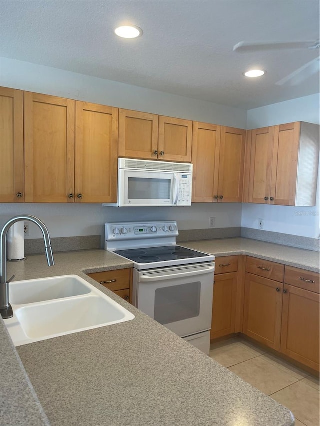 kitchen featuring light tile patterned flooring, white appliances, and sink