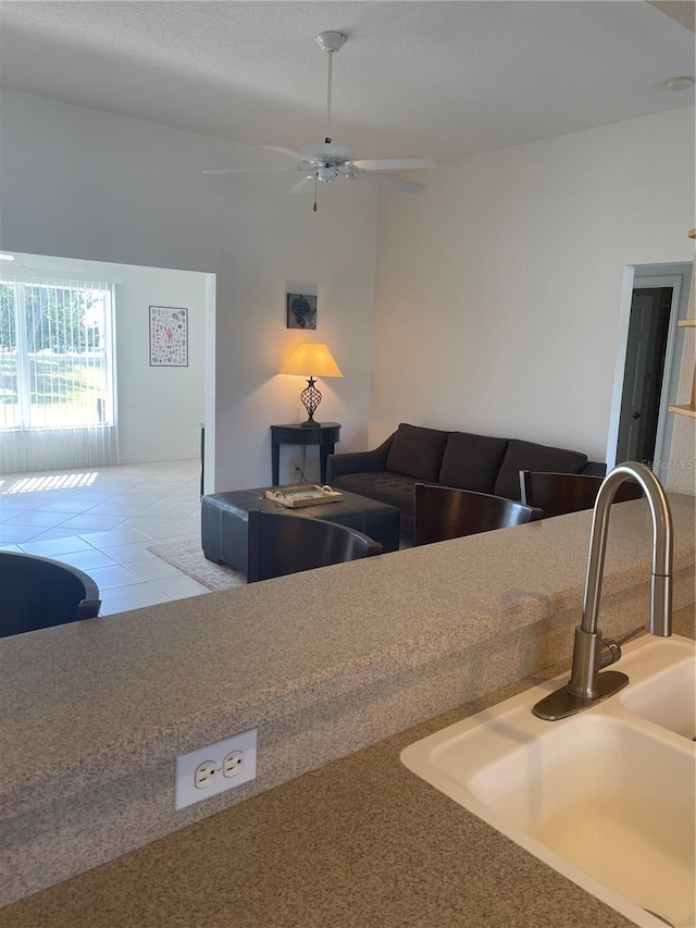 kitchen featuring ceiling fan, sink, and tile patterned flooring