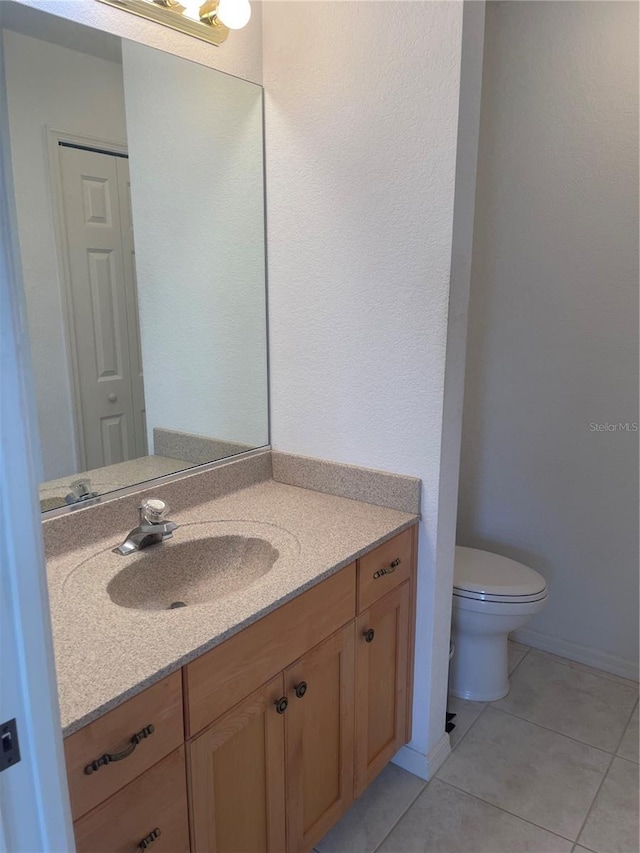 bathroom with vanity, tile patterned flooring, and toilet