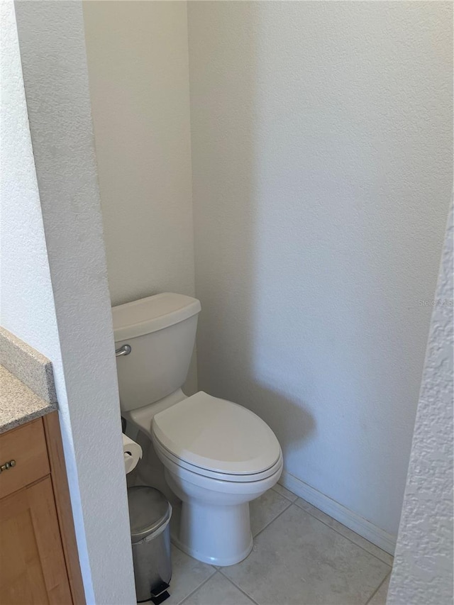 bathroom with tile patterned flooring, vanity, and toilet