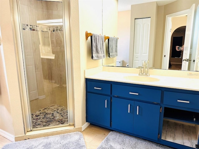 bathroom featuring vanity, an enclosed shower, and toilet