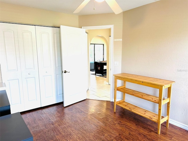 interior space with dark wood-type flooring, a closet, and ceiling fan