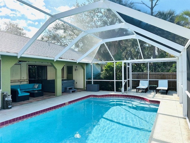 view of pool featuring outdoor lounge area, a patio, and a lanai