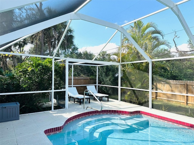 view of pool featuring glass enclosure and a patio area