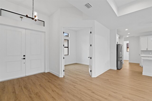 foyer entrance featuring baseboards, visible vents, light wood-type flooring, a chandelier, and recessed lighting