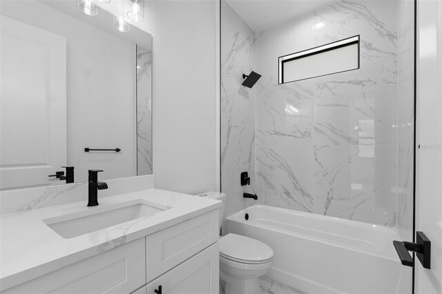 bathroom featuring toilet, marble finish floor, vanity, and bathing tub / shower combination